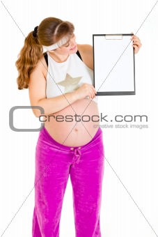 Pregnant woman holding blank clipboard
