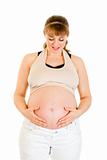 Smiling pregnant woman holding her tummy isolated on white
