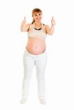Smiling pregnant woman showing  thumbs up gesture
