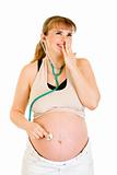 Surprised pregnant woman holding stethascope on her tummy
