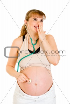 Surprised pregnant woman holding stethascope on her tummy
