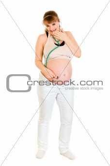 Surprised pregnant female holding stethascope on her belly
