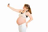 Smiling pregnant woman photographing herself
