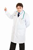 Serious medical doctor pointing finger in corner
