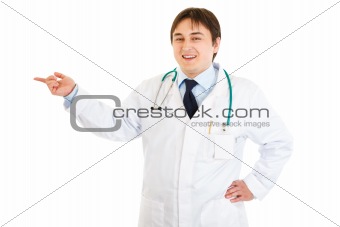 Smiling medical doctor pointing finger at something
