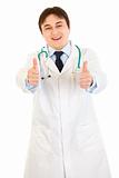 Smiling medical doctor showing thumbs up gesture
