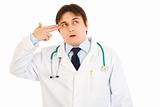 Stressed medical doctor with gun shaped hand
