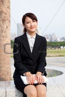 Young and smiling businesswoman  holding a laptop