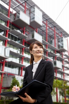 Young beautiful business woman Sitting in front of the modern building