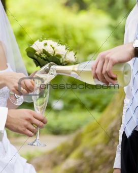 Man fills newly-married couple's glasses with champagne