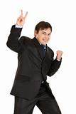 Happy young businessman showing victory gesture
