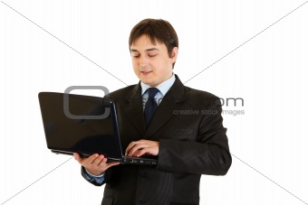 Smiling modern businessman working on laptop
