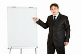 Smiling modern businessman giving presentation using flipchart, place for text
