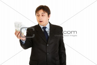 Surprised modern businessman holding money in his hand
