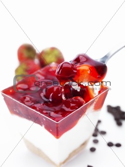 cheese cake in a glass bowl with cherries and strawberries