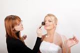 Professional wedding make-up is being applied to beautiful bride