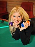 beautiful smiling woman with many billiard balls indoors