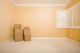 Moving Boxes in Empty Room with Copy Space on Blank Wall.