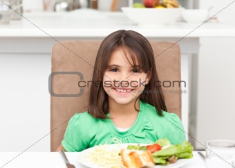 Portrait of a little girl eating pasta and salad
