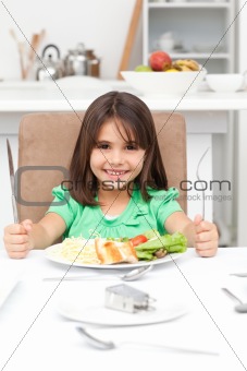Adorable llittle girl holding forks to eat pasta and salad
