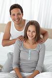 Portrait of a happy man massaging his girlfriend on the bed