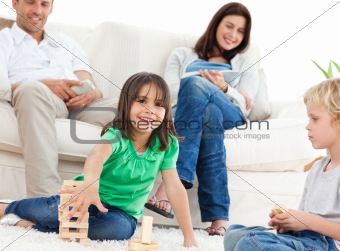 Happy children playing with dominoes in the living room 