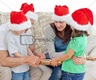 Family opening crackers together on the sofa