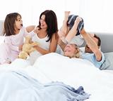 Happy family playing together on the bed 