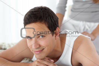 Portrait of a happy man being massaged by his girlfriend