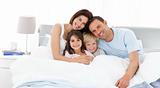 Happy children with their parents on the bed