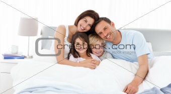 Happy children with their parents on the bed