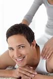 Cheerful man enjoying a back massage from his girlfriend