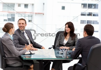 Handsome manager laughing during a meeting with his team
