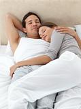 Cute couple sleeping in each other's arms on their bed