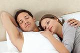 Serene woman lying on her boyrfriend's arms while sleeping