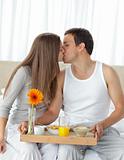 Happy woman kissing her boyfriend for bringing the breakfast