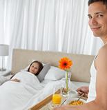 Portrait of a man bringing the breakfast to his girlfriend
