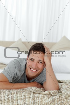 Portrait of a cheerful man lying on his bed