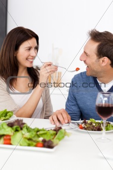 Passionate woman giving a tomato to her boyfriend while having l