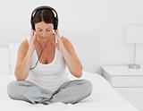 Woman listening to music on her bed