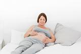 Pregnant woman cuddling her belly