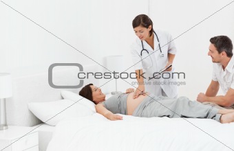 Pregnant woman with her husband and a nurse 