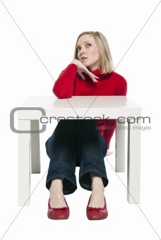 Young woman sitting at funny small desk