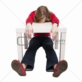 Young woman sleeping at funny small desk