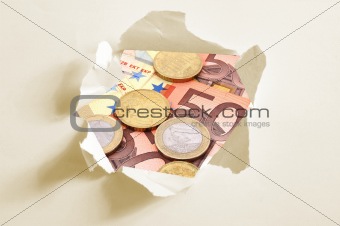 euro money behind hole in paper