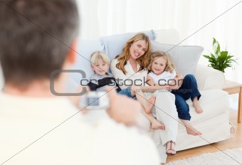 Man taking a photo of his family at home