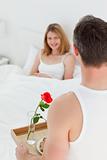 Joyful lovers having breakfast in their bed