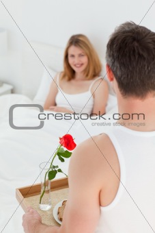 Joyful lovers having breakfast in their bed