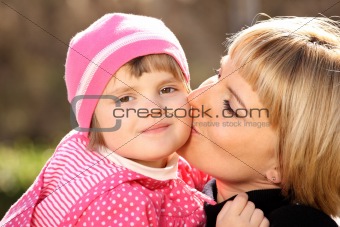 Mother kissing her little girl