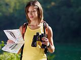 woman hiking with binoculars and map
